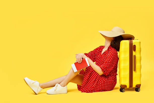 istock woman with suitcase going traveling on yellow background. 1310559669