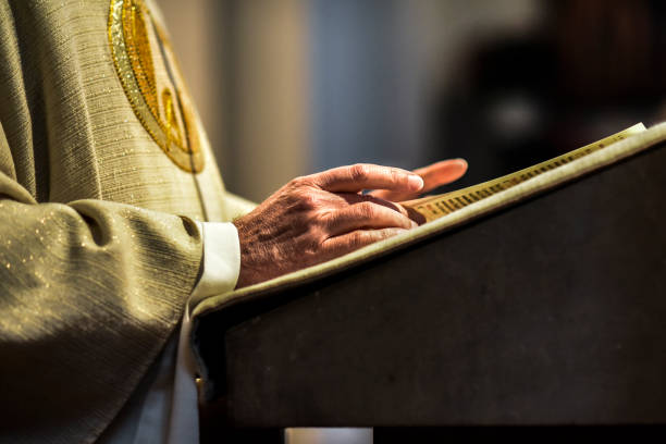 Hands of jesuit priests are folded during prayer at a ceremony in Cataldo, Idaho.