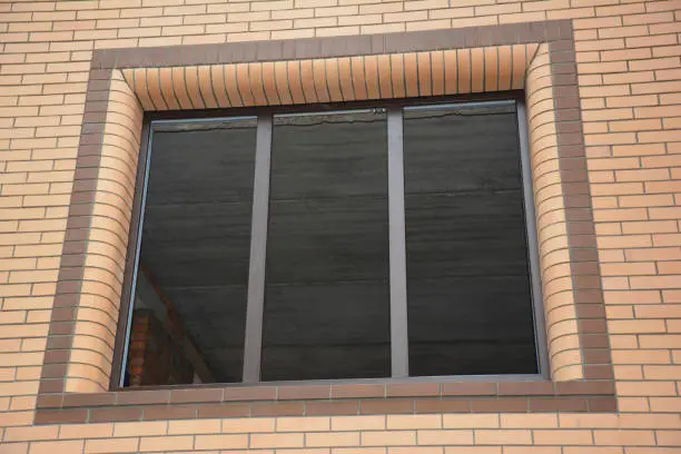Plastic window installation: An outdoor view on an unglazed uPVC window frame installed without glass panels in a new built house.