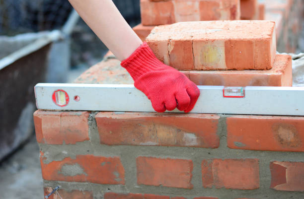 istock Brick masonry: A bricklayer is checking the evenness of a brick wall, brick foundation using a spirit level. 1310562684