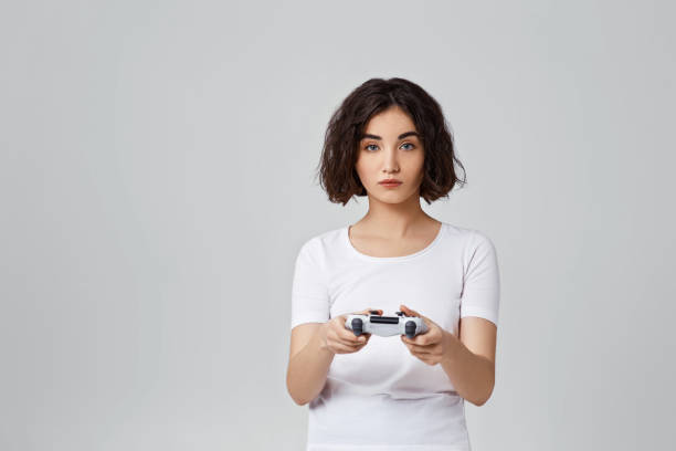 istock girl playing video games on gray background 1310562849
