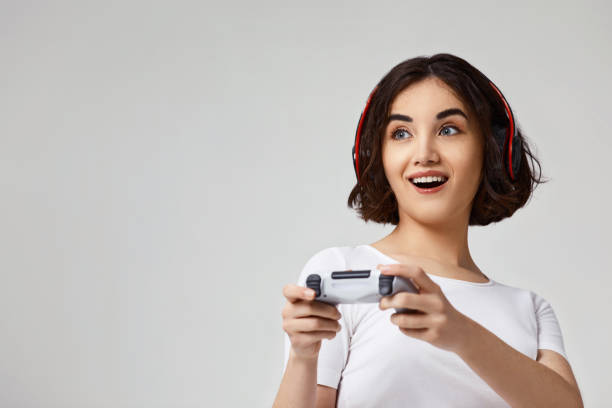 istock girl playing video games on gray background 1310562891