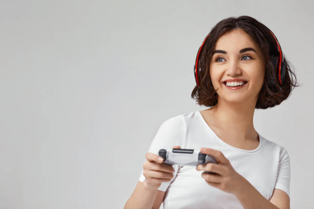 istock girl playing video games on gray background 1310562897