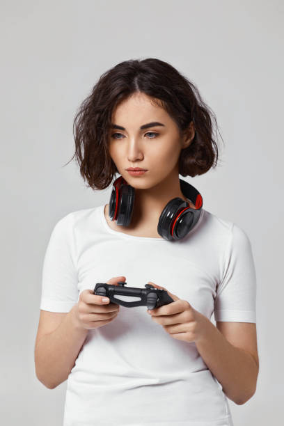 istock girl playing video games on gray background 1310562903