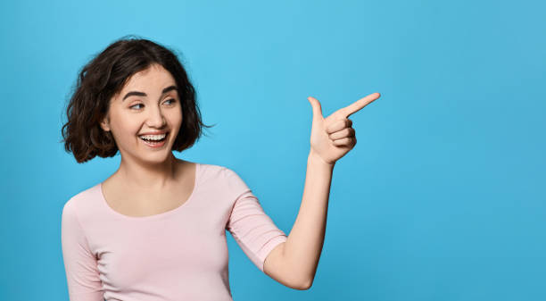 istock smiling young beautiful woman is pointing up 1310563644