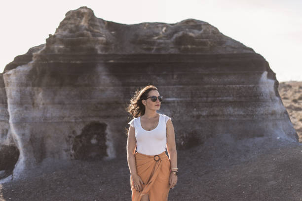 istock Beautiful woman with sunglasses on volcanic scenario 1310565703