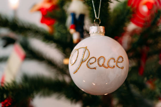 istock Close-Up Of Christmas Decoration With Peace Text Hanging On Tree 1310565848