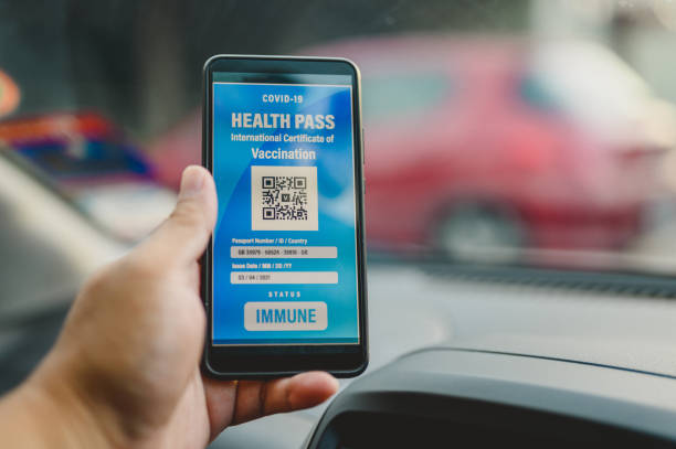 A Man holding smartphone with digital certificate of covid-19 vaccination A Man holding smartphone with digital certificate of covid-19 vaccination inside a car. vaccine passport photos stock pictures, royalty-free photos & images