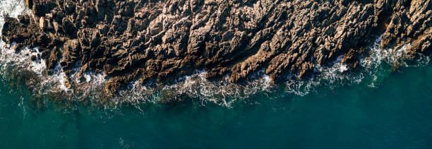 acque oceaniche selvagge dall'alto - onde che colpiscono rocce - fotografia aerea. - rough waters foto e immagini stock