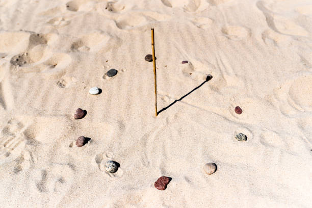 Sundial on the beach made of a stick and stones. Sundial on the beach made of a stick and stones. ancient sundial stock pictures, royalty-free photos & images
