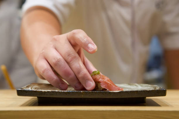 新鮮なわさびを入したマグロ寿司をセラミックプレートに盛り付けます。日本の寿司屋でおまかせ体験をお楽しみください。 - 寿司 ストックフォトと画像