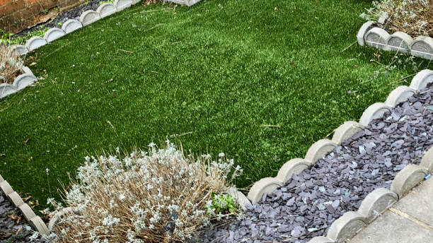istock Image of low maintenance design front lawn, artificial grass with slate edging and low brick wall, patio paving slabs 1310569587