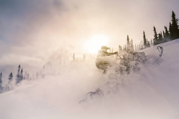 силуэт райдера на снегоходе во время заката в красивом пейзаже - snowmobiling snow winter mountain стоковые фото и изображения