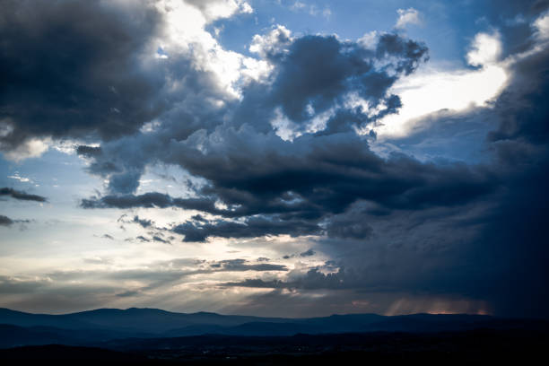 istock Beautiful clouds with sun penetrating them during sunset. 1310571827