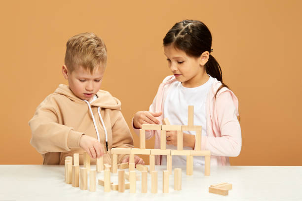 istock children plays with wooden constructor on desk. 1310573021