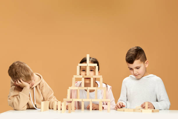 istock children plays with wooden constructor on desk. 1310573042