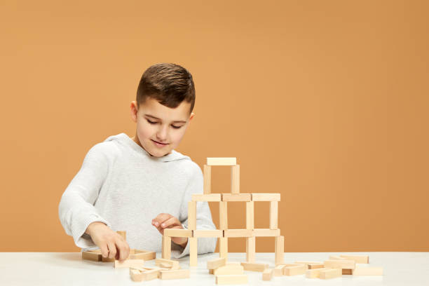 istock children plays with wooden constructor on desk. 1310573067