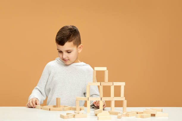 istock children plays with wooden constructor on desk. 1310573073