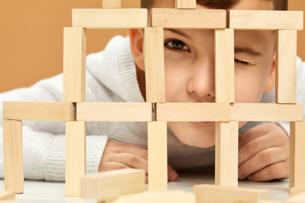 istock children plays with wooden constructor on desk. 1310573090