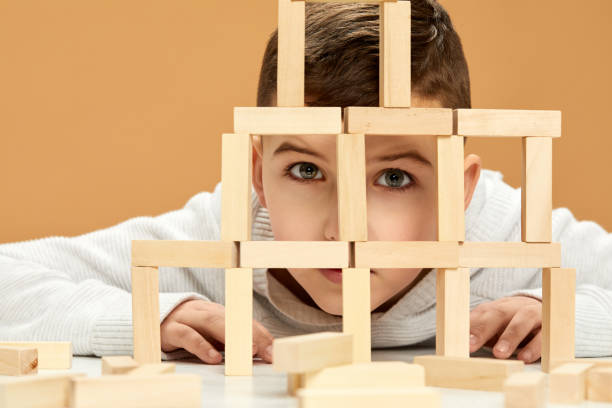 istock children plays with wooden constructor on desk. 1310573099
