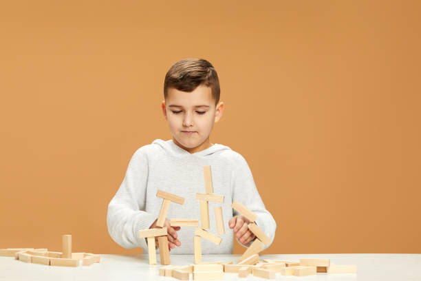 istock children plays with wooden constructor on desk. 1310573110