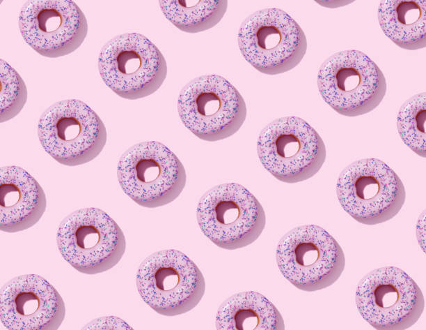 istock Seamless pattern with donuts with pink glaze on pink background, top view. 1310574278