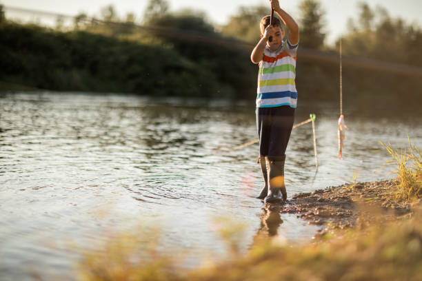 istock Happy boy caught a fish on the river 1310575760