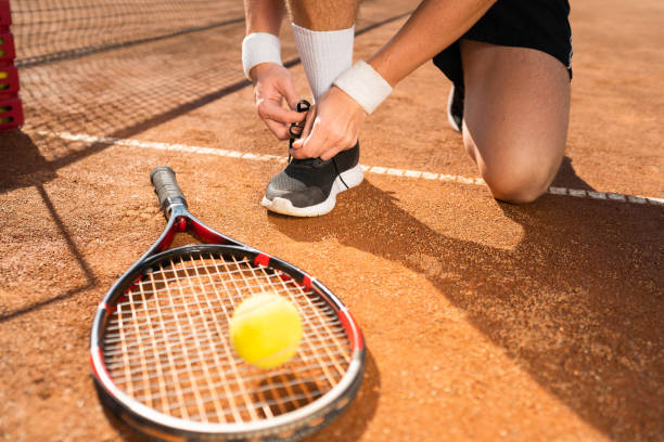 istock Unrecognizable tennis player tying shoelaces while playing 1310576285