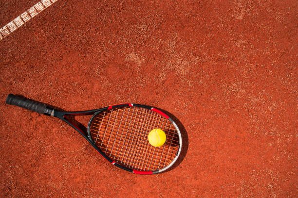 vista superior de la raqueta de tenis con pelota que yacía en la superficie de la cancha. concepto deportivo - tennis court tennis net indoors fotografías e imágenes de stock