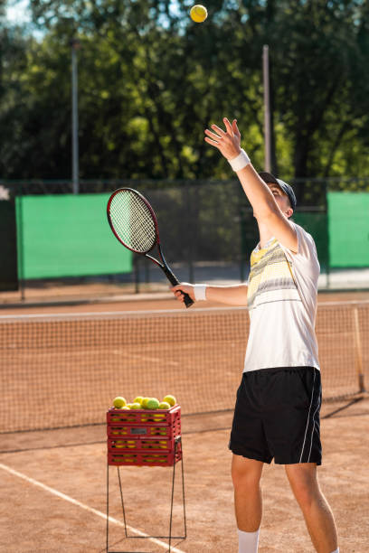 istock Man practicing playing tennis. Tennis player serves 1310576328