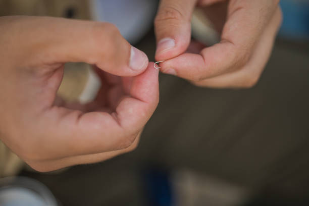 istock Close up of a hands holding a small fishing hook 1310577110