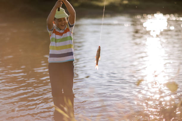 istock Happy boy caught a fish on the river 1310577568