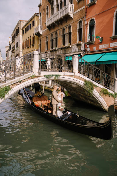 istock Couple Standing In Gondola At Canal 1310583131