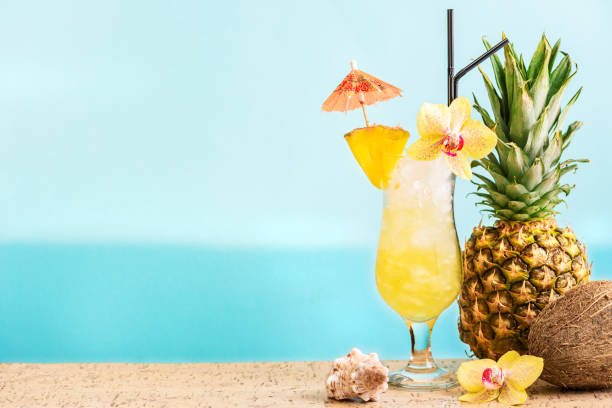 Summer tropical cocktail drinks Summer tropical cocktail drink, fruits and flowers, blue sea background, copy space. Summer vacation and beach relax concept. Golden Eye pineapple and rum cocktail recipe. tropical cocktail stock pictures, royalty-free photos & images