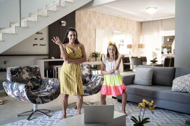 mother and daughter dancing in front of laptop at home - parent mother music listening imagens e fotografias de stock