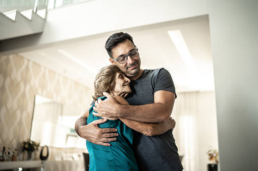 Grandson embracing grandmother at home