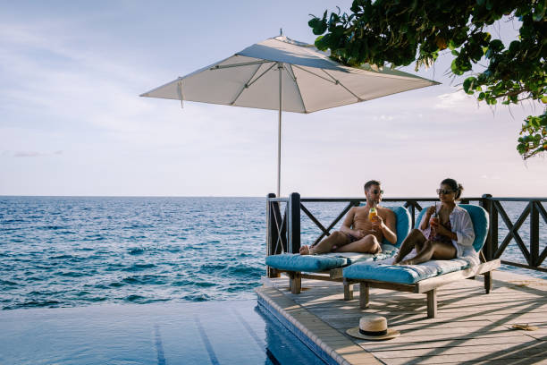 istock Relaxing summer beach , Sunbathing deck and private swimming pool with Palm trees near beach and panoramic sea view at luxury house Curacao 1310584598