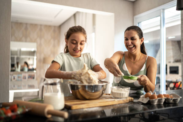 Mother and daughter preparing a bread together at home