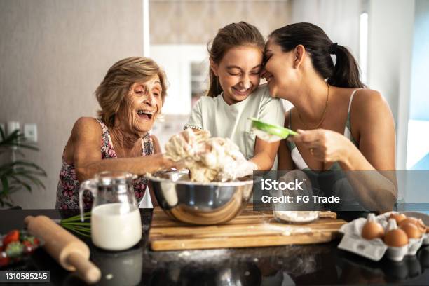 Multigeneration Family Preparing A Breadcake At Home Stock Photo - Download Image Now