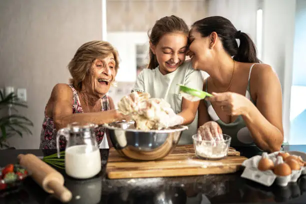 Photo of Multi-generation family preparing a bread/cake at home