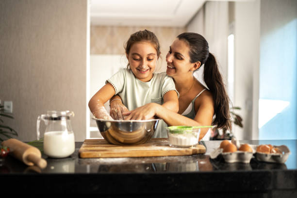 istock Mother and daughter preparing a bread together at home 1310585249