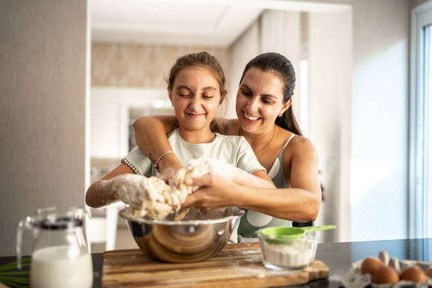istock Mother and daughter preparing a bread together at home 1310585252