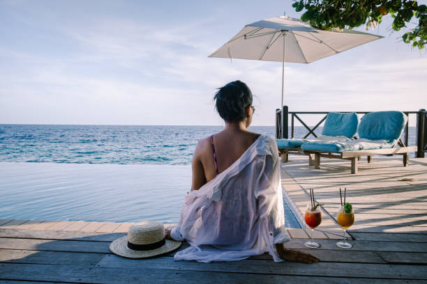 istock Relaxing summer beach , Sunbathing deck and private swimming pool with Palm trees near beach and panoramic sea view at luxury house Curacao 1310585333