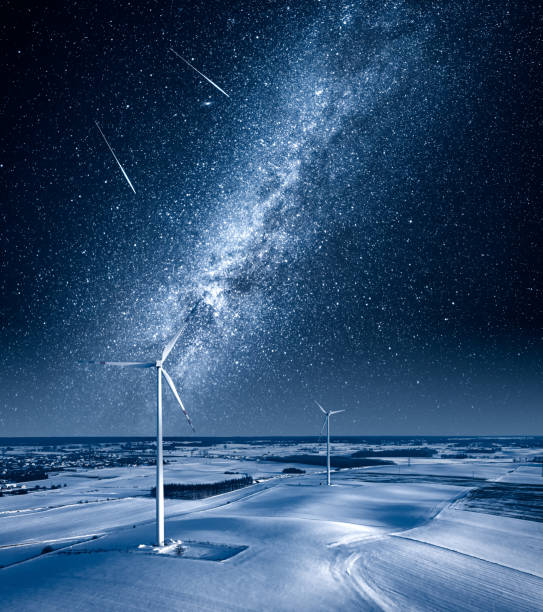 istock Milky way over wind turbine on field at winter. 1310588092