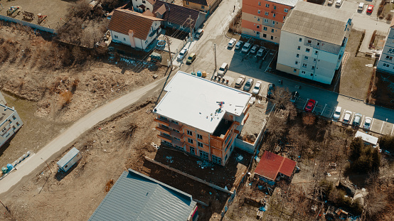 Aerial view of an apartment building with flat roof in construction, ballasted system with geotextile, PVC or EPDM membrane