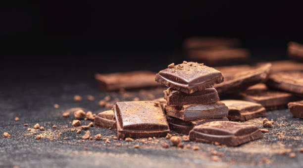 istock Chocolate bars on black slate background with cocoa powder 1310594730