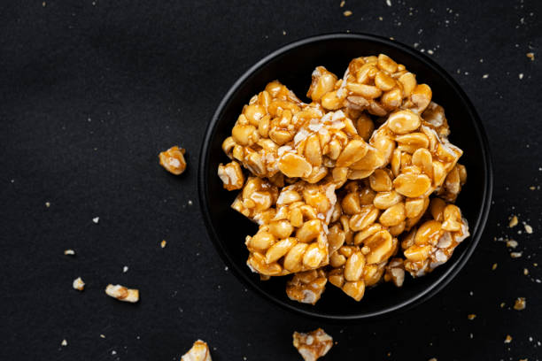 istock Peanut kozinaki on black background, top view 1310594749