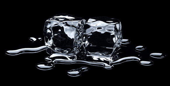 Melting ice cubes with water drops on black background