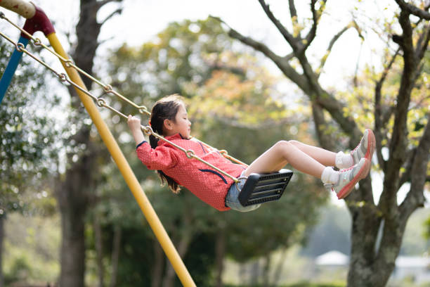 istock Girl playing on a swing in a spring park 1310596176