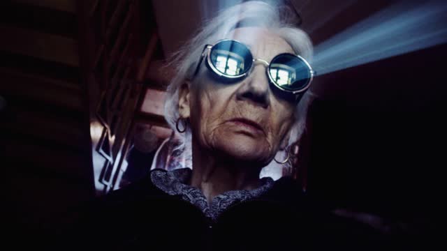 Creepy old woman in miror sunglasses.